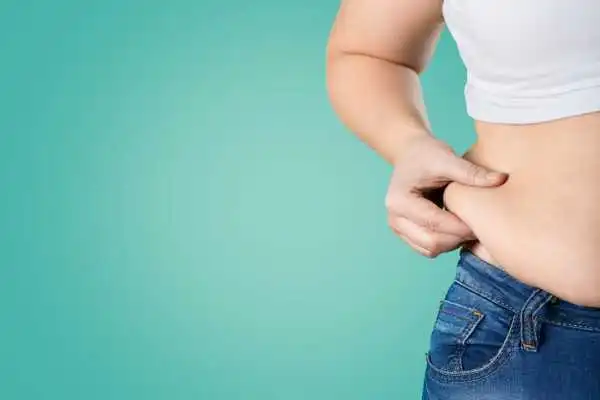 Image of woman pinching her love handles to show weight gain Lincolnshire